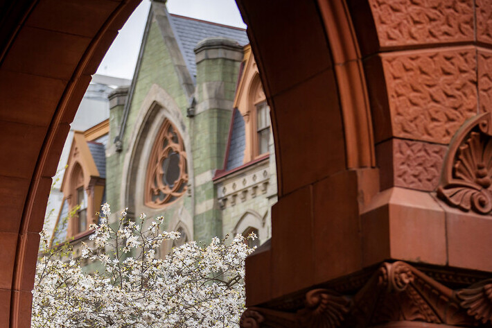 view through a campus brick archway to a Penn landmark